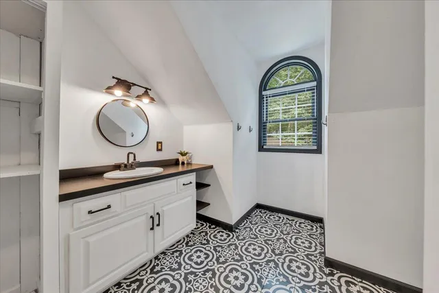 a bathroom with a granite countertop sink mirror vanity and a