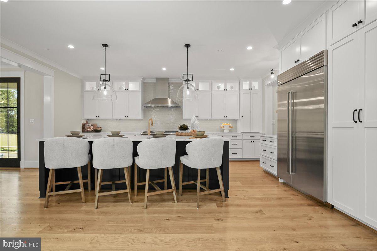 204 Oxford Street Chevy Chase, MD 20815 - Photo 14 of 59 a large kitchen with a dining table chairs and white cabinets