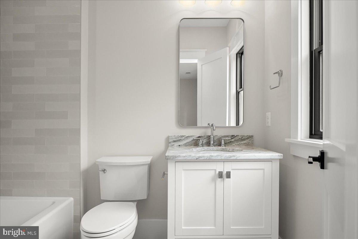 204 Oxford Street Chevy Chase, MD 20815 - Photo 47 of 59 a bathroom with a granite countertop toilet sink and mirror