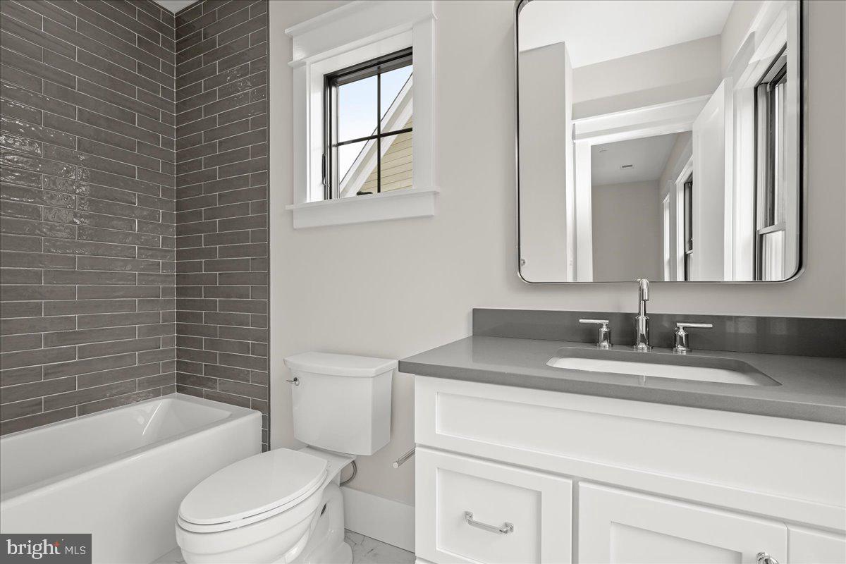 204 Oxford Street Chevy Chase, MD 20815 - Photo 50 of 59 a bathroom with a granite countertop toilet sink and mirror