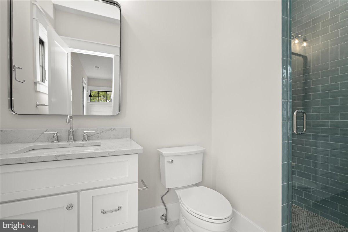 204 Oxford Street Chevy Chase, MD 20815 - Photo 53 of 59 a bathroom with a granite countertop toilet sink vanity and mirror