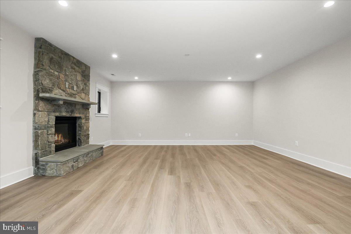 204 Oxford Street Chevy Chase, MD 20815 - Photo 55 of 59 an empty room with wooden floor and a fireplace