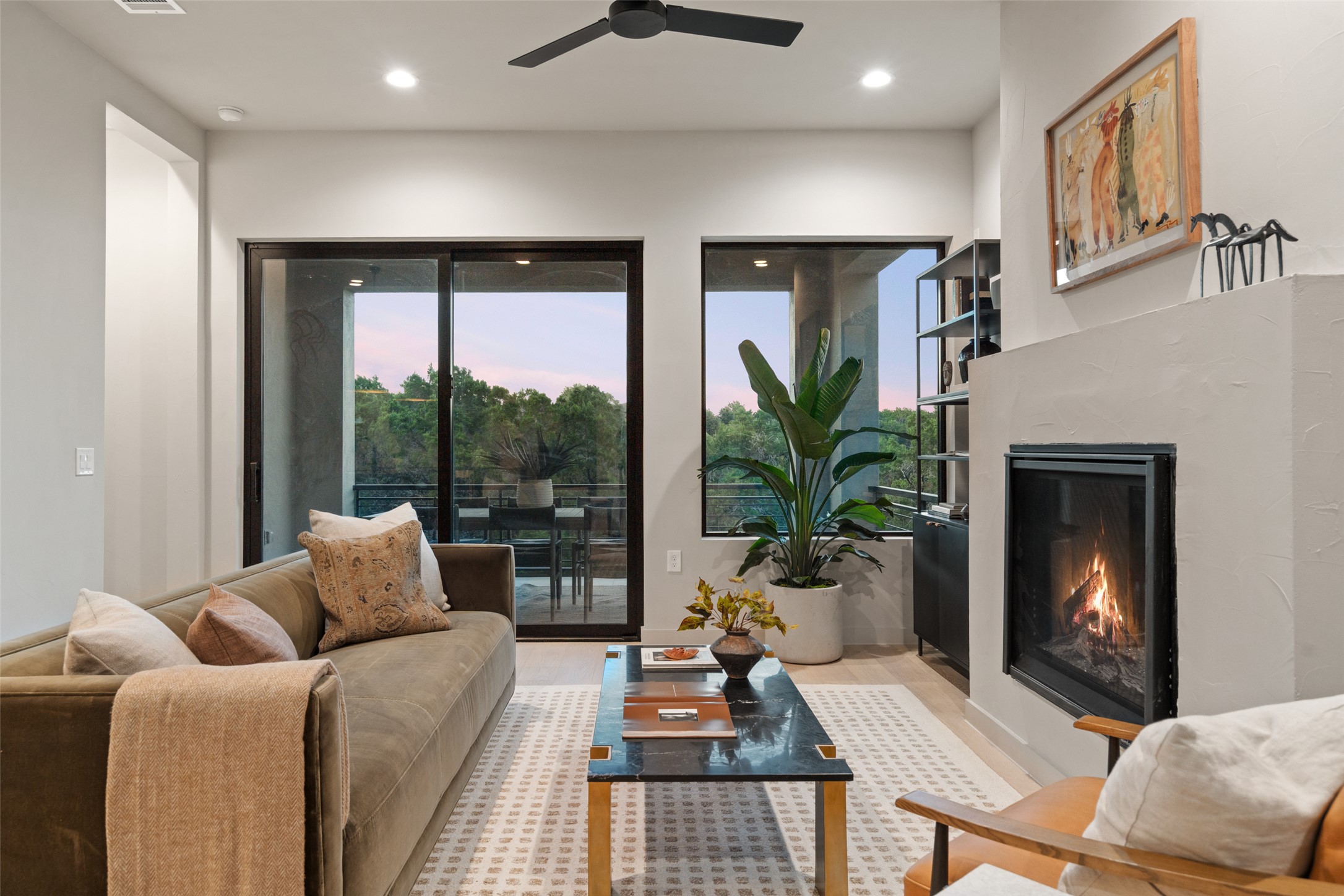 9803 Ribelin Ranch Court, Unit 6 Austin, TX 78750 - Photo 2 of 31 A cozy living space offers a warm fireplace, recessed lighting, and a serene balcony view.