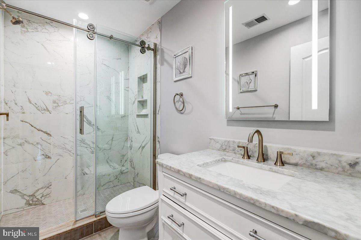 43501 Monarch Beach Square Leesburg, VA 20176 - Photo 27 of 43 a bathroom with a granite countertop sink a toilet and shower
