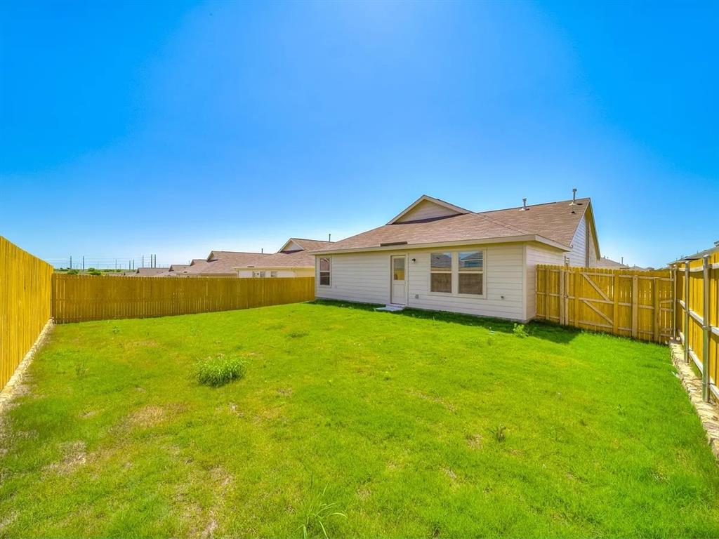 352 Sun Bluff Road Fort Worth, TX 76052 - Photo 32 of 33 Expansive rear yard featuring green lawn, a privacy fence, and a gate providing property access