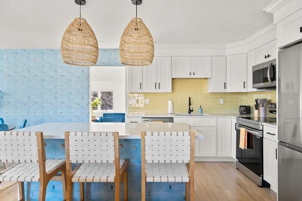 a kitchen with stainless steel appliances granite countertop a white cabinets and stove