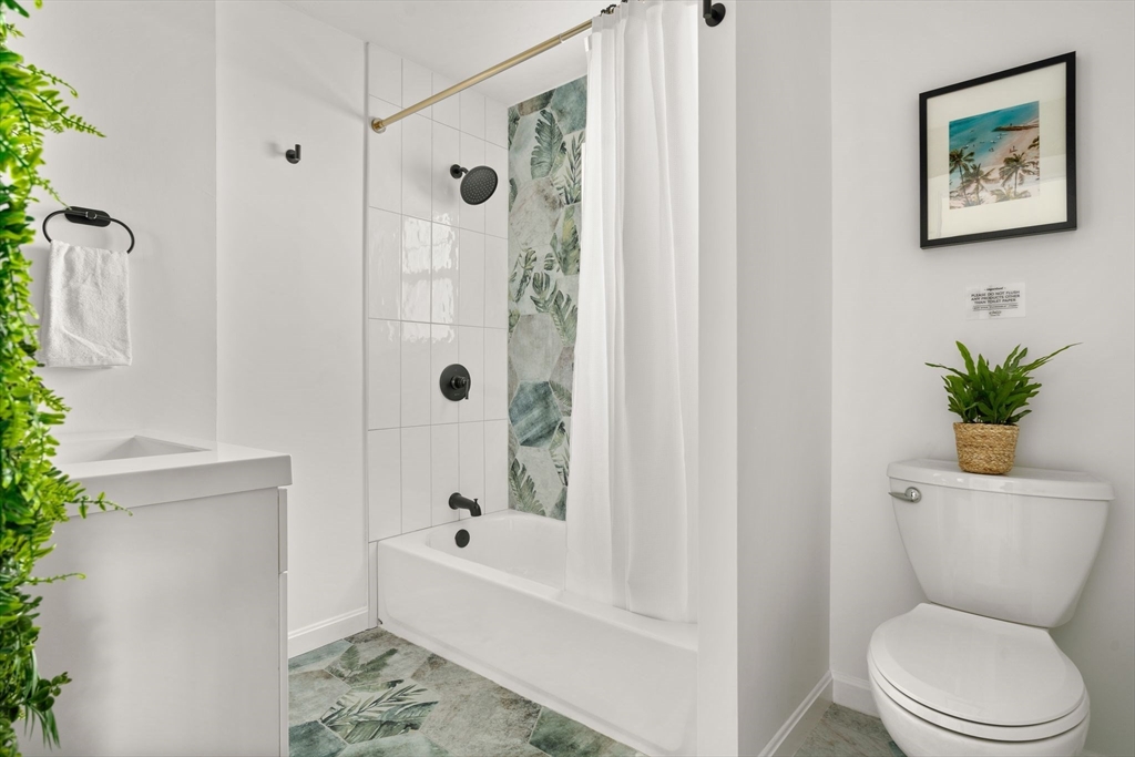 30 Coburn Street Hull, MA 02045 - Photo 33 of 39 a white toilet sitting next to a bath tub shower