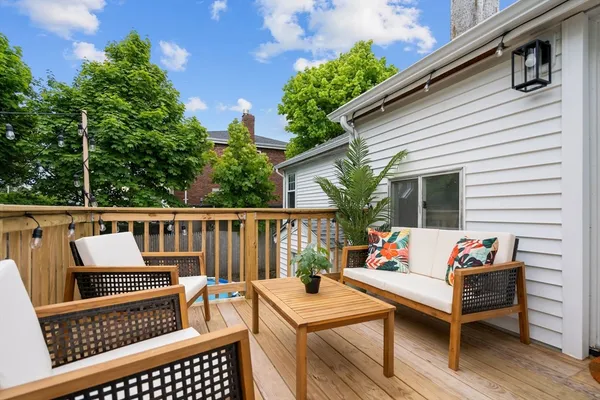 a view of a patio with couches chairs and wooden floor