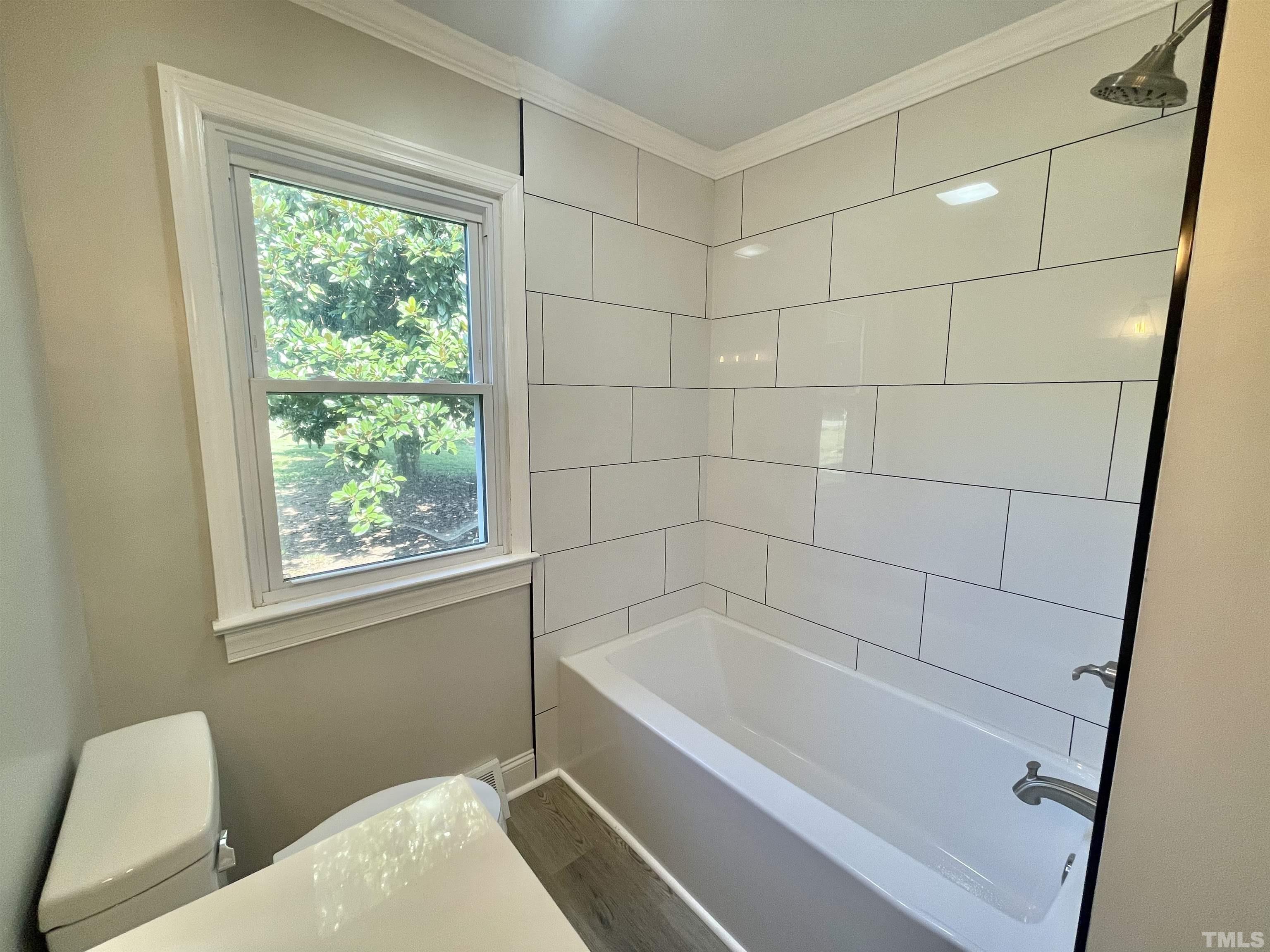 2221 Burlington Road Roxboro, NC 27574 - Photo 14 of 28 a bathroom with a bathtub and window