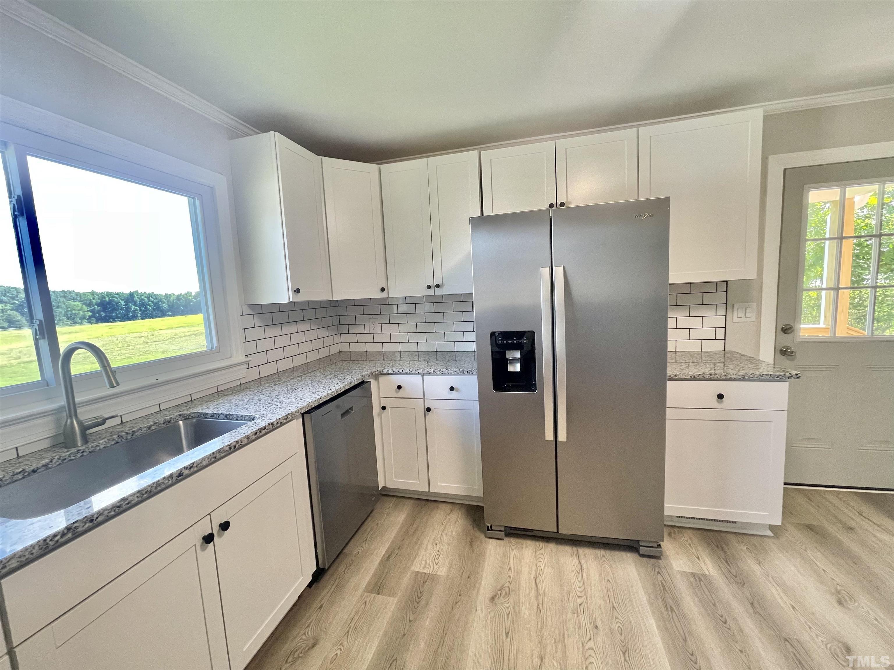 2221 Burlington Road Roxboro, NC 27574 - Photo 8 of 28 a kitchen with a refrigerator sink and cabinets