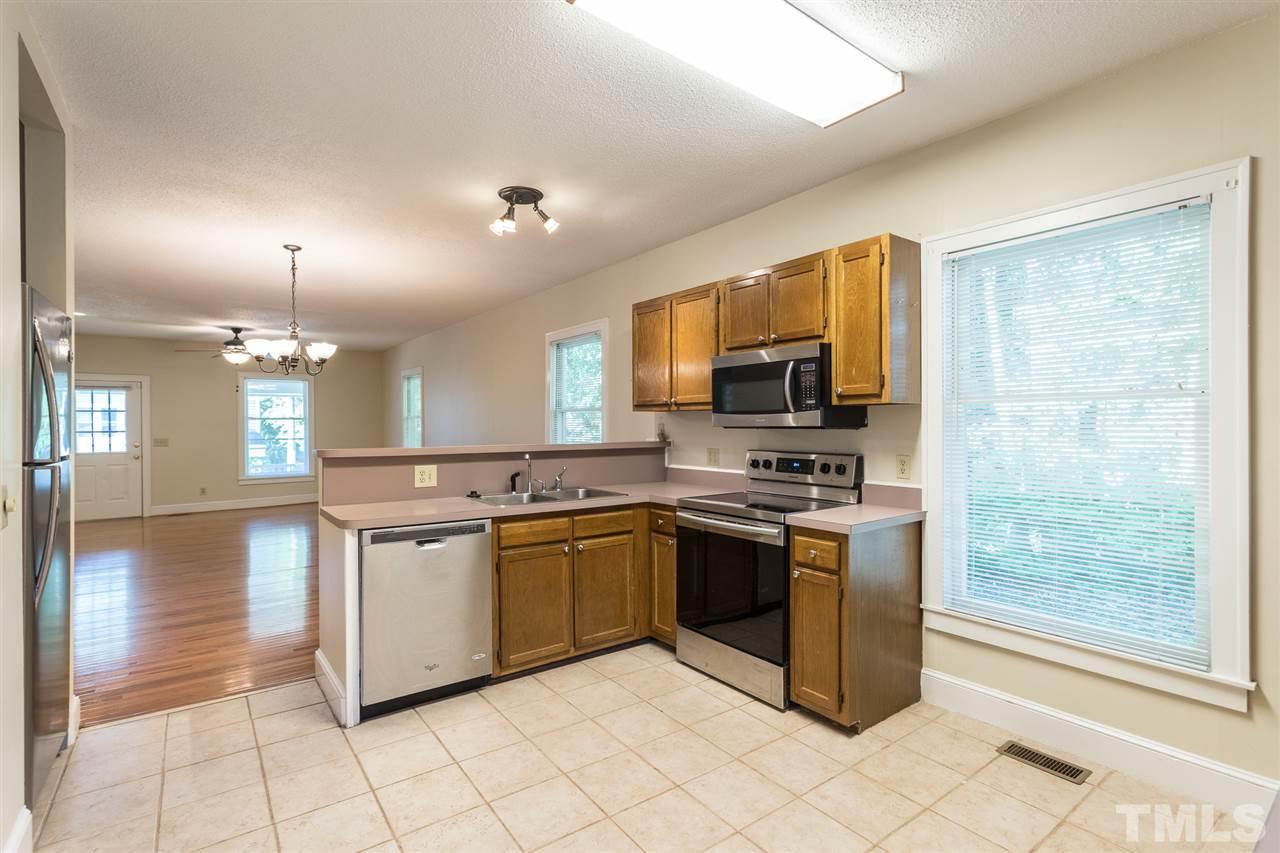 507 Pace Street Raleigh, NC 27604 - Photo 12 of 25 a kitchen with stainless steel appliances granite countertop a stove top oven a sink and a refrigerator