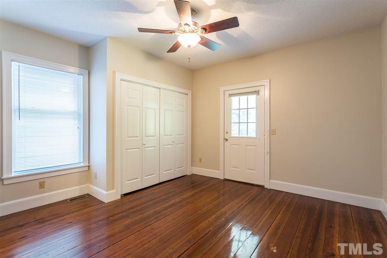 507 Pace Street Raleigh, NC 27604 - Photo 16 of 25 an empty room with wooden floor chandelier fan and windows