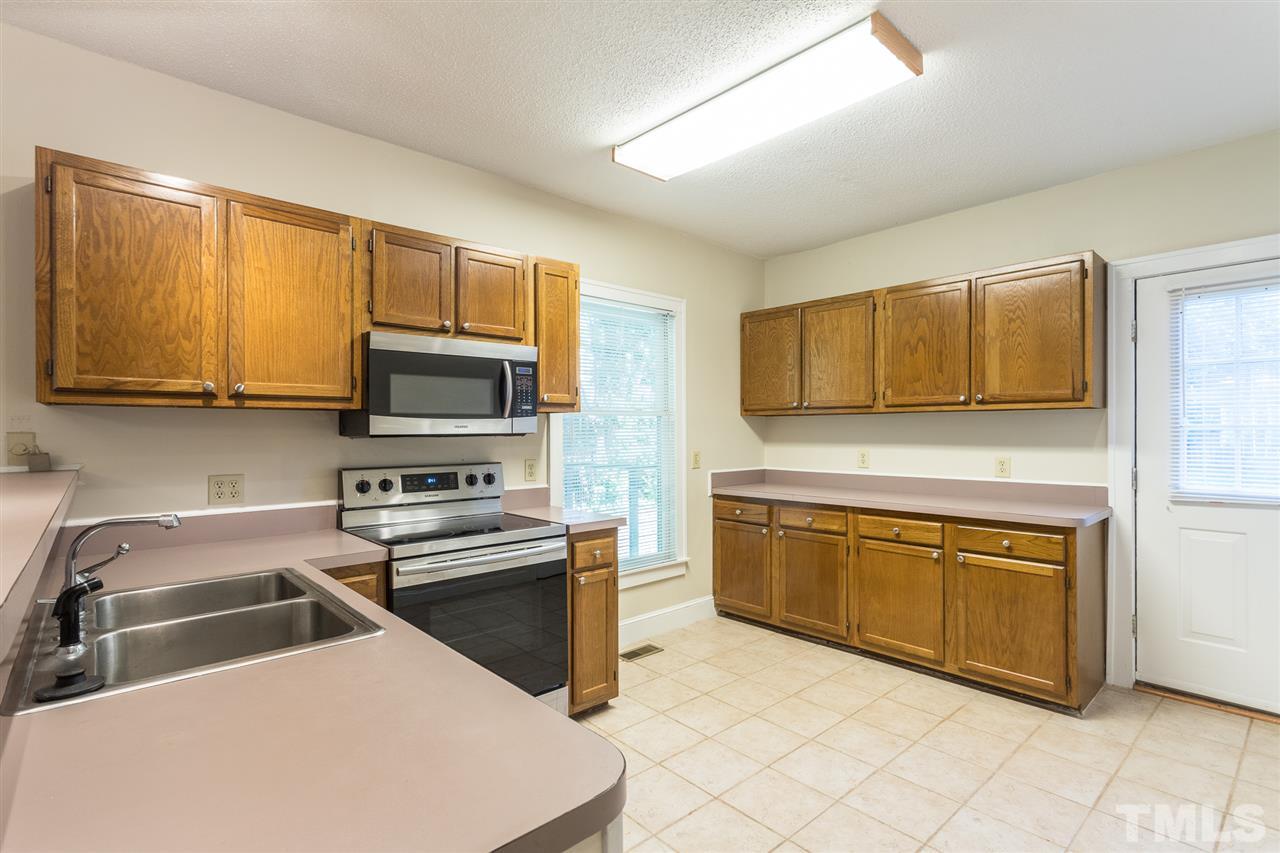 507 Pace Street Raleigh, NC 27604 - Photo 8 of 25 a kitchen with stainless steel appliances granite countertop a sink a stove a microwave and wooden cabinets