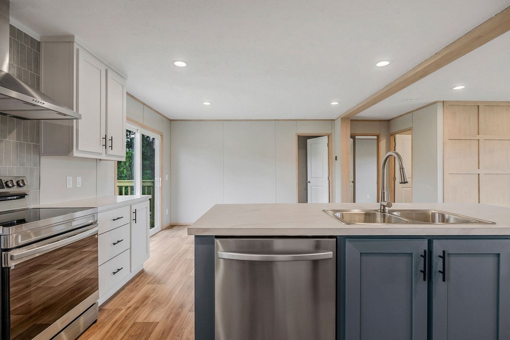9107 Barnes Ridge Road Monroe, TN 38573 - Photo 11 of 30 a kitchen with stainless steel appliances granite countertop a sink cabinets and wooden floor