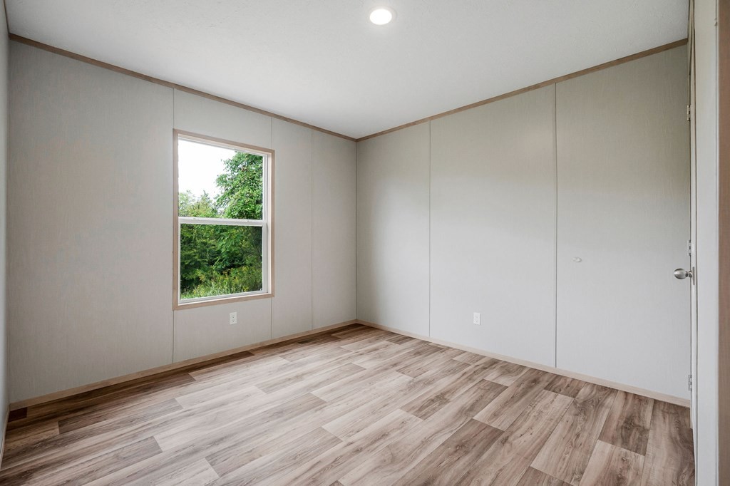 9107 Barnes Ridge Road Monroe, TN 38573 - Photo 18 of 30 an empty room with wooden floor and windows