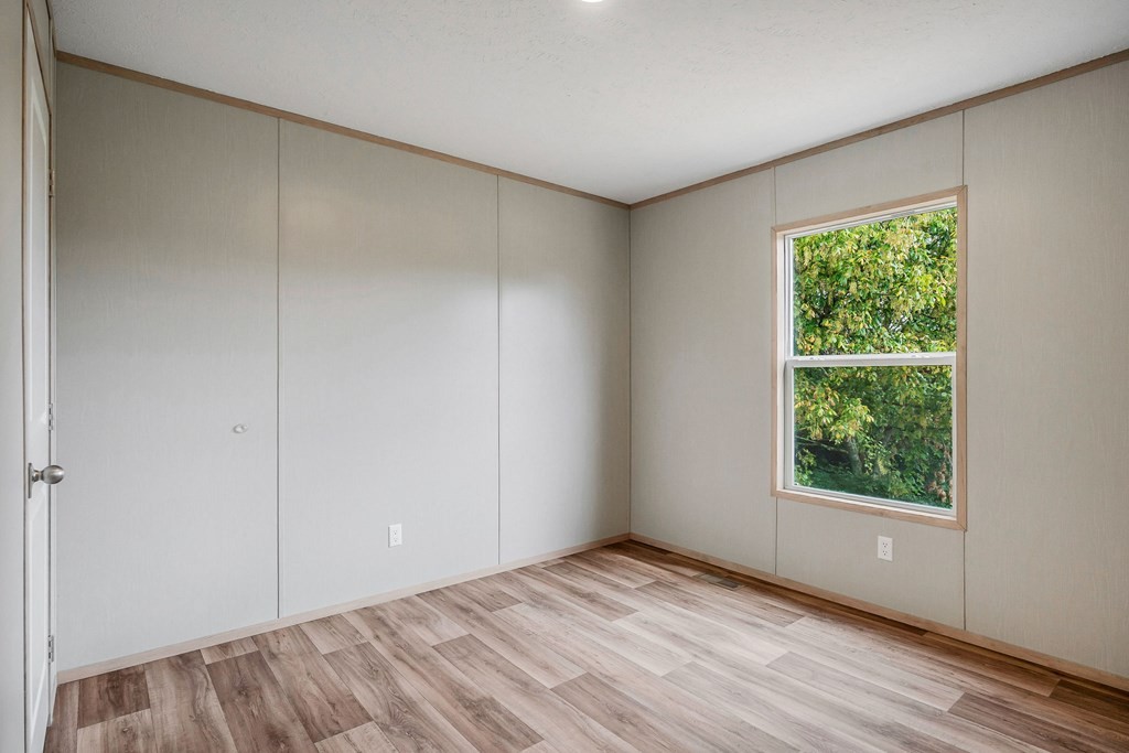 9107 Barnes Ridge Road Monroe, TN 38573 - Photo 20 of 30 a view of an empty room with wooden floor and a window