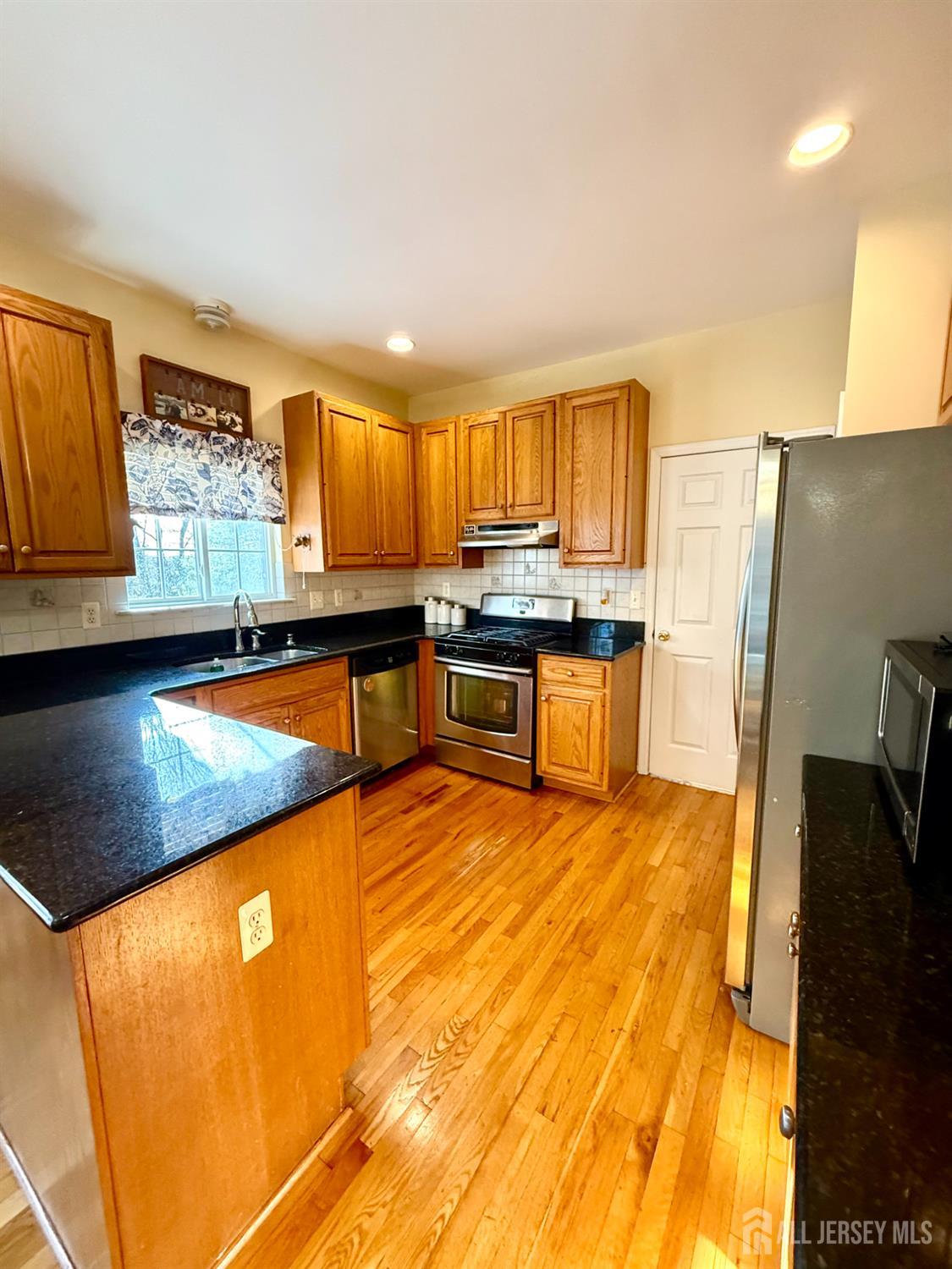127 Disbrow Road Old Bridge, NJ 07747 - Photo 36 of 50 a kitchen with stainless steel appliances granite countertop a stove a sink and a refrigerator
