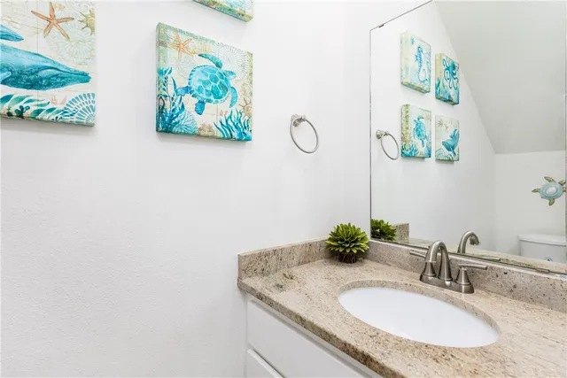 a kitchen with stainless steel appliances a white refrigerator a sink a stove and white cabinets with wooden floor