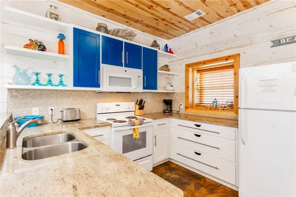 a kitchen with stainless steel appliances granite countertop a sink a stove and cabinets