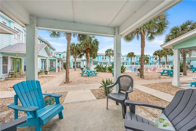 a view of a patio with dining table and chairs under an umbrella