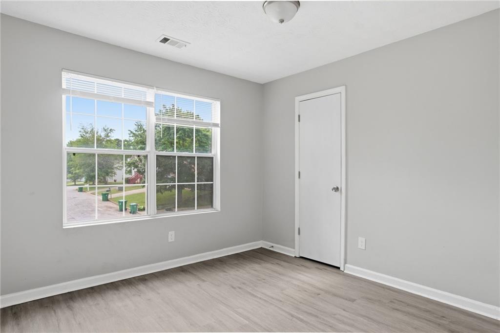 5855 Crescent Ridge Court Lithonia, GA 30058 - Photo 25 of 46 an empty room with wooden floor and windows