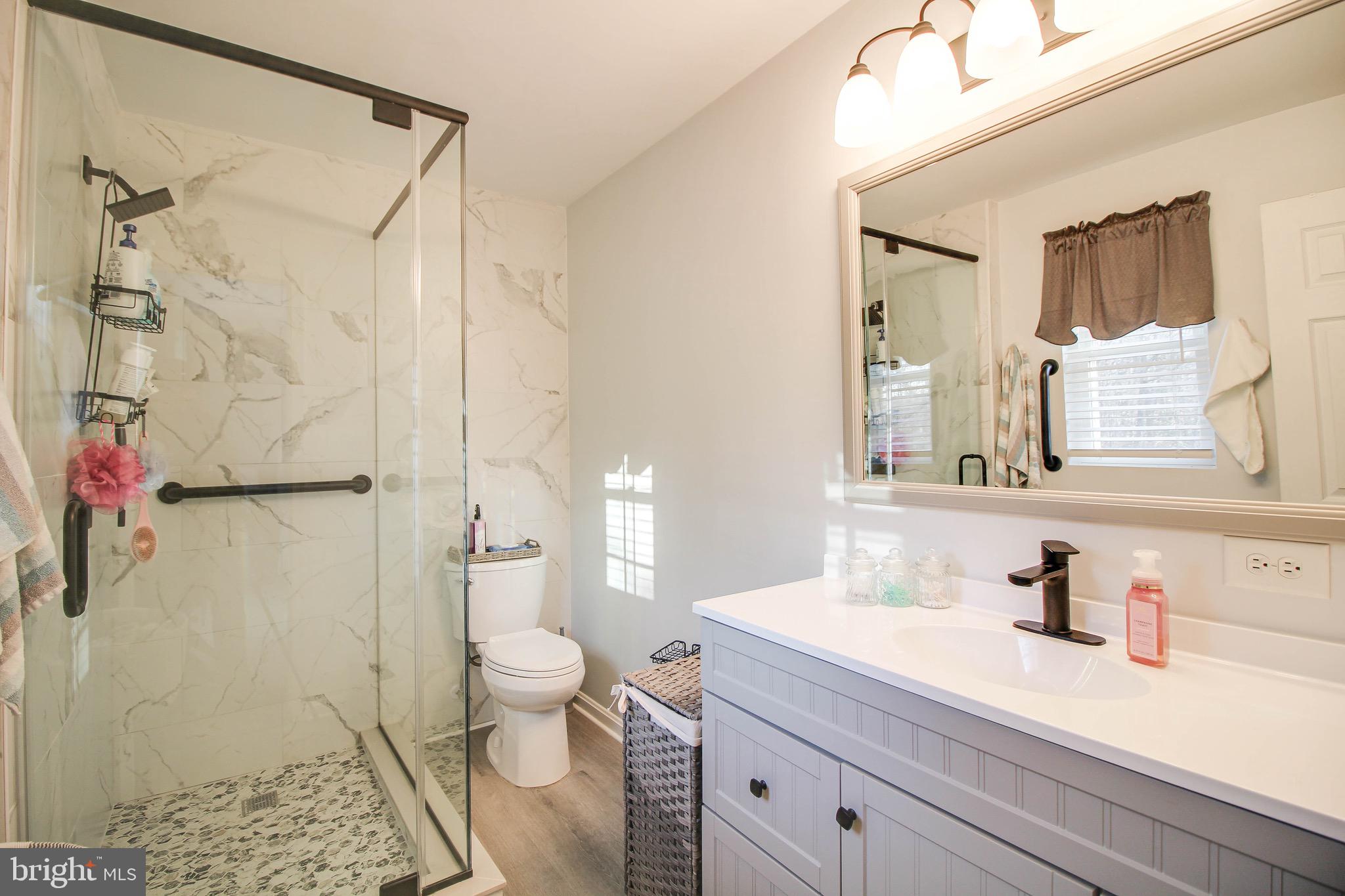 8000 Solley Road Glen Burnie, MD 21060 - Photo 17 of 44 a bathroom with a granite countertop sink a toilet and shower