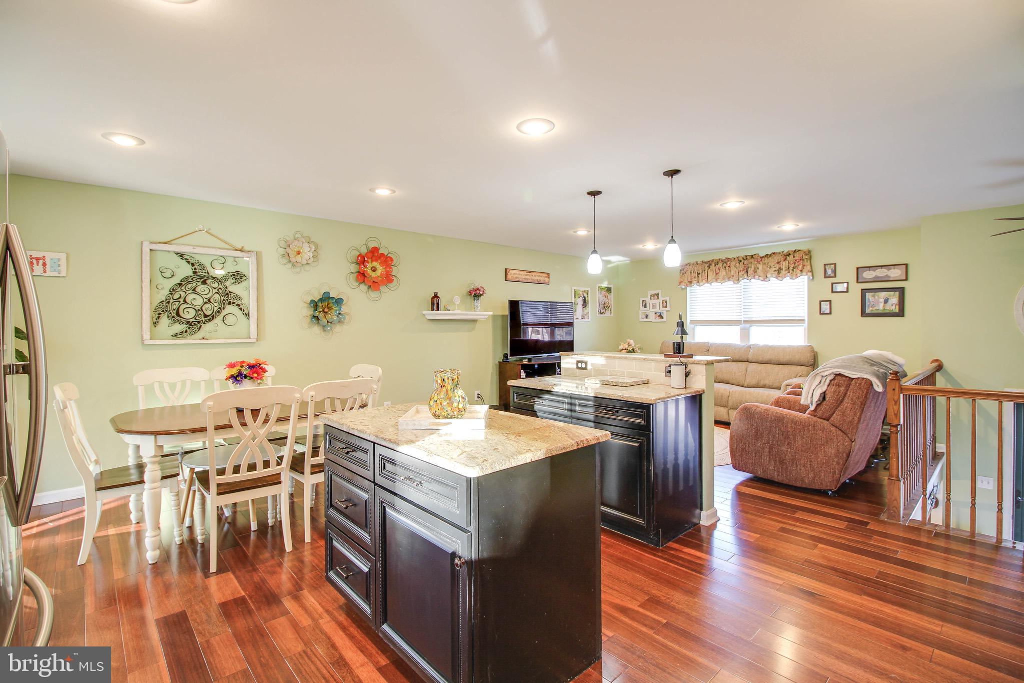 8000 Solley Road Glen Burnie, MD 21060 - Photo 10 of 44 a kitchen with stainless steel appliances granite countertop a stove a sink a dining table and chairs with wooden floor