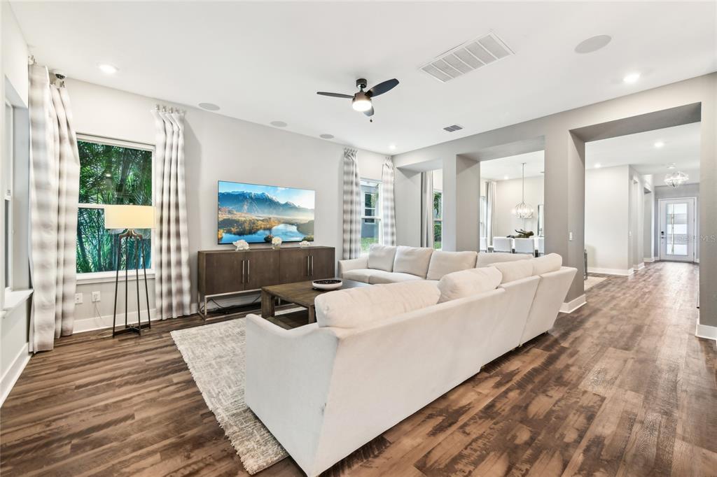 6054 Bimini Twist Loop Orlando, FL 32819 - Photo 10 of 76 a living room with furniture a large window wooden floor and a rug