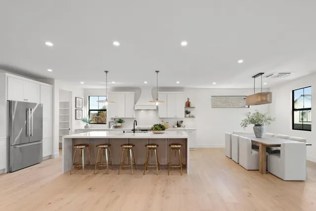 a kitchen with stainless steel appliances kitchen island granite countertop a table and chairs in it