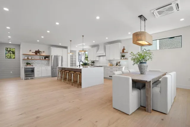 a kitchen with white cabinets and window