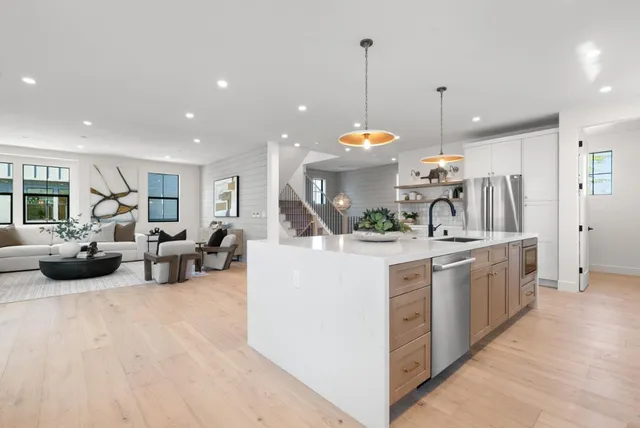 a spacious bedroom with a bed a window and potted plant on a table