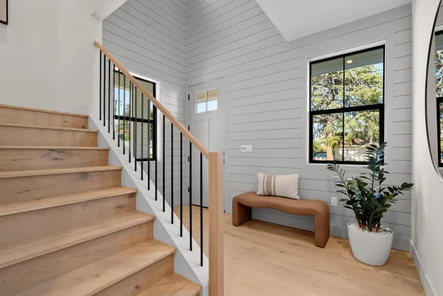 a view of a house with wooden deck and furniture
