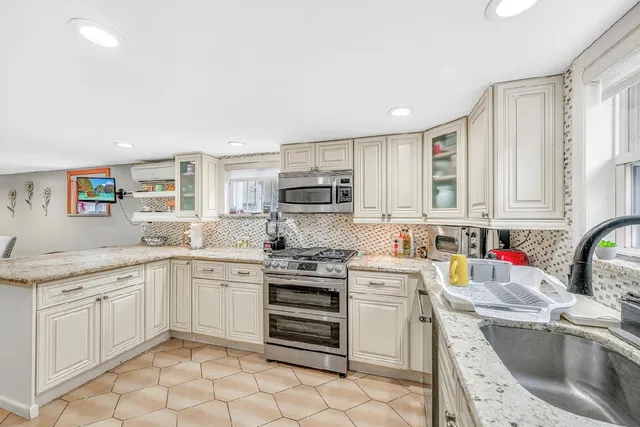 a kitchen with a sink stove top oven and cabinets