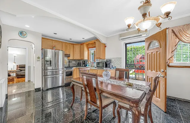 a dining room with stainless steel appliances a dining table and chairs