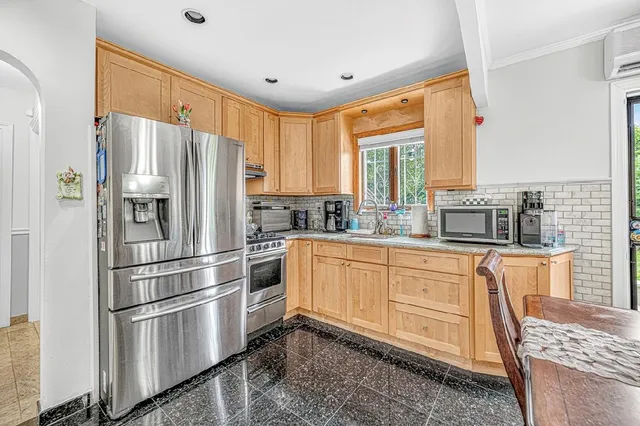 a kitchen with stainless steel appliances granite countertop a refrigerator stove and cabinets