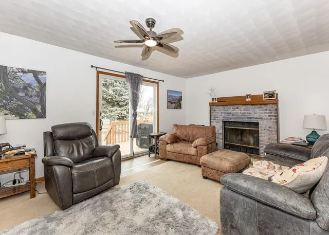 a living room with furniture fireplace and a large window