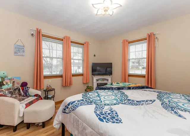 a living room with furniture a flat screen tv and a large window