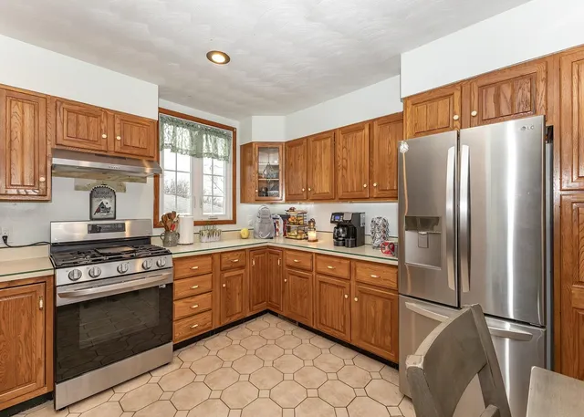 a kitchen with stainless steel appliances granite countertop a stove a refrigerator and a sink