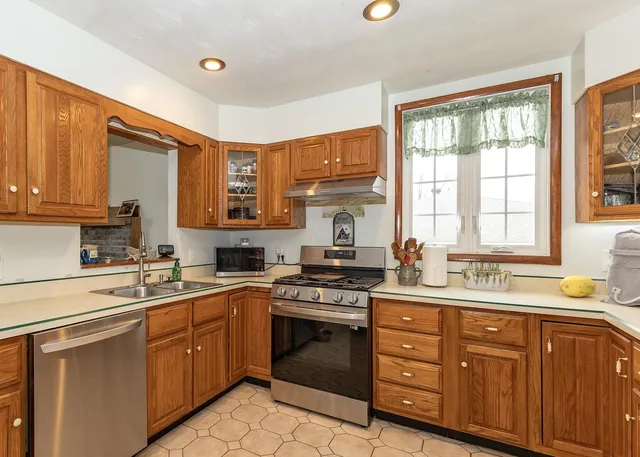 a kitchen with a sink stove top oven and cabinets