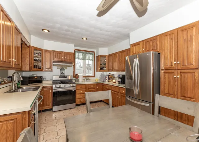 a kitchen with stainless steel appliances granite countertop a refrigerator stove and sink