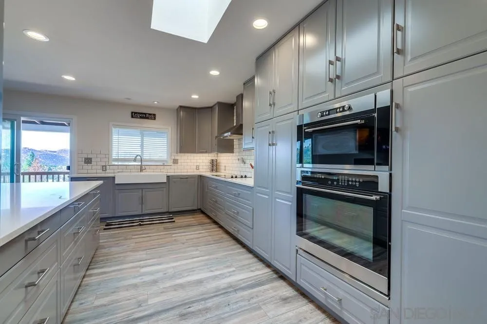 1125 South Grade Road Alpine, CA 91901 - Photo 13 of 50 a kitchen with stainless steel appliances kitchen island granite countertop a stove a sink and a microwave