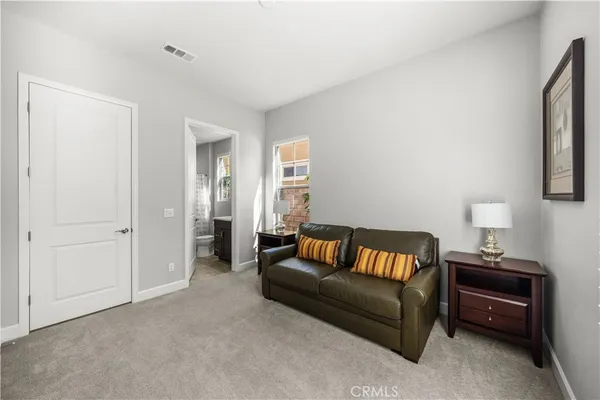 a bedroom with a bed and dresser next to a window