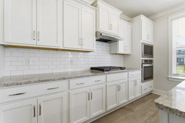 a kitchen with granite countertop white cabinets and sink