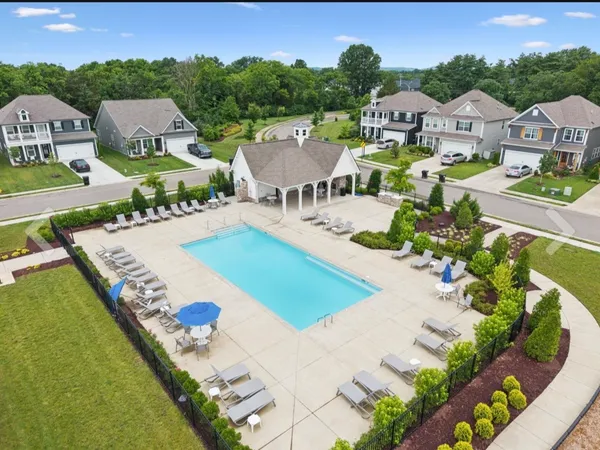 an aerial view of a house with swimming pool and mountains