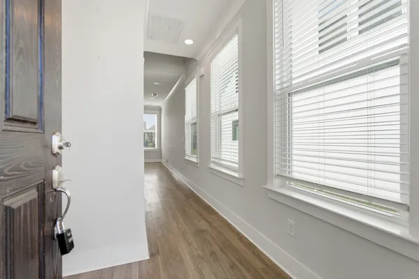 a view of a hallway with wooden floor and staircase