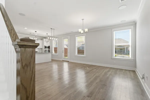 a view of empty room with wooden floor and window