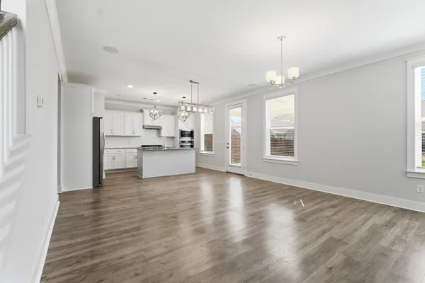 a view of a kitchen with a fridge wooden floor and a window