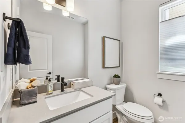 a bathroom with a sink vanity mirror and toilet