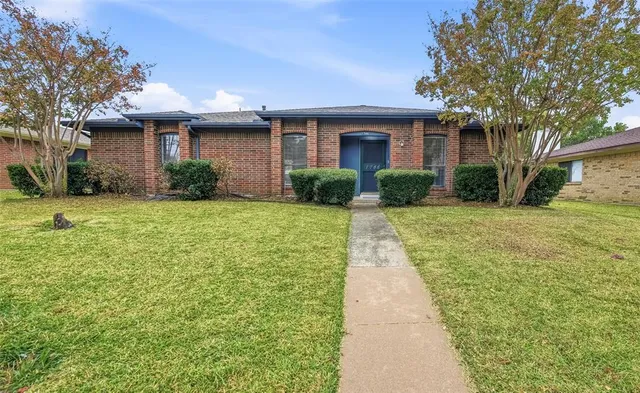 a front view of a house with yard and green space