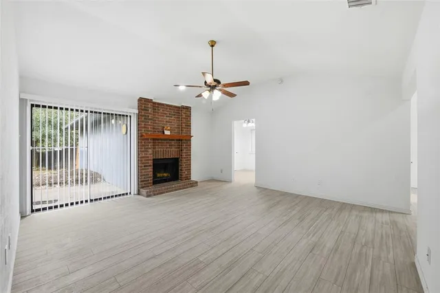 a view of a livingroom with a fireplace and wooden floor